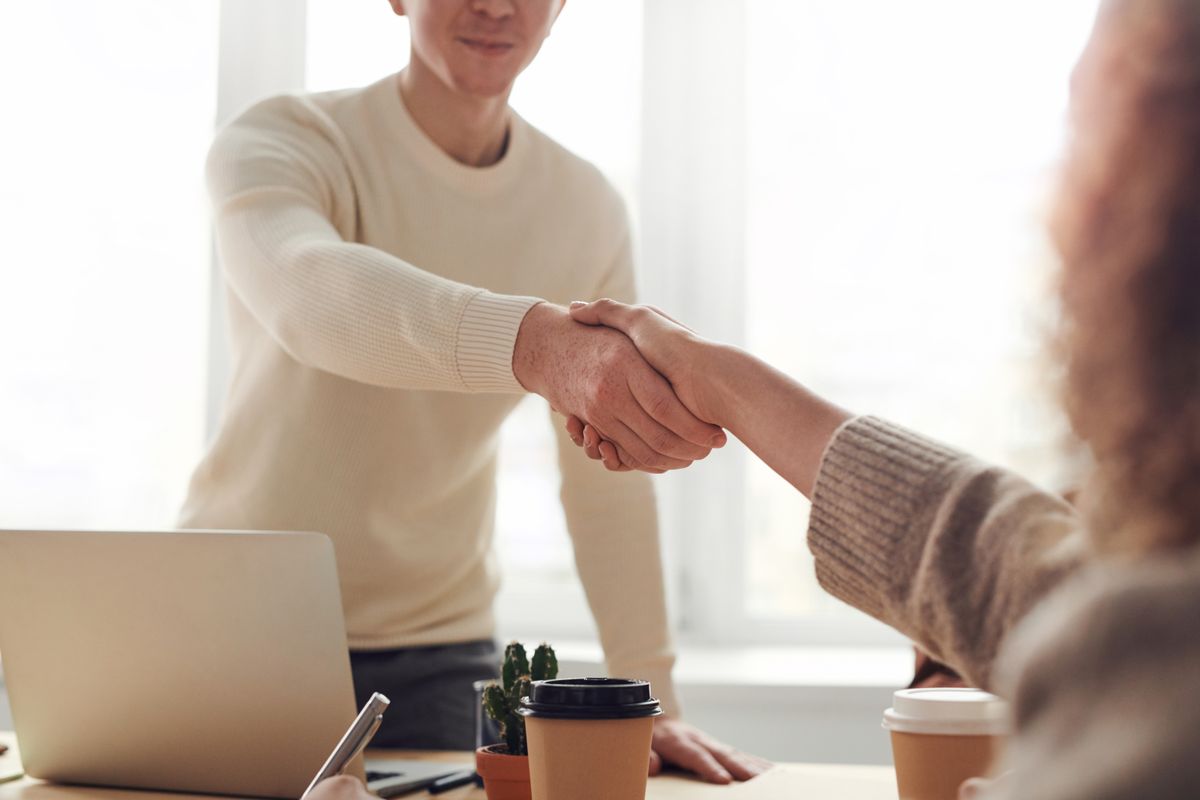 Due professionisti si stringono la mano in un ufficio luminoso